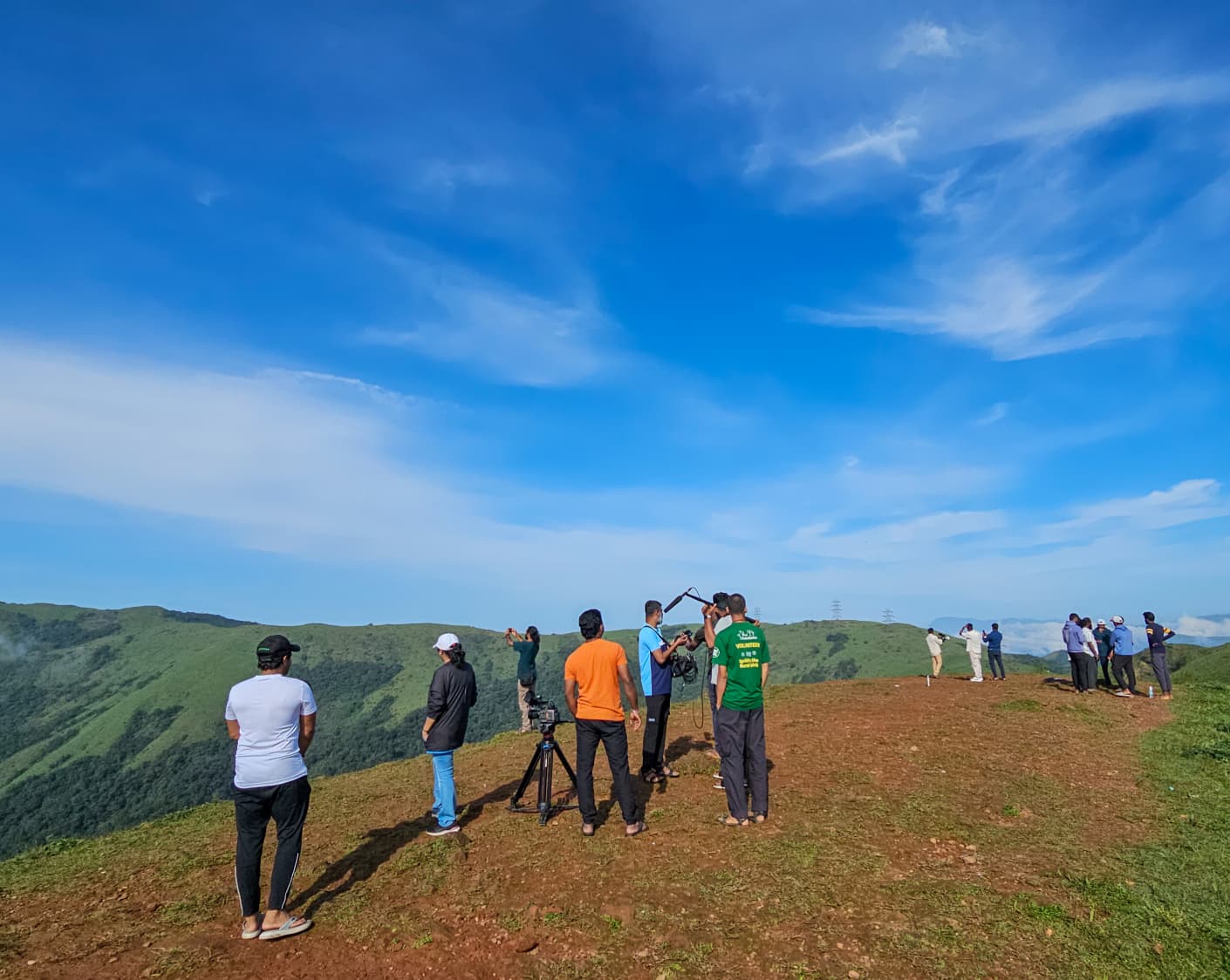 Crew and villagers gathered on open high ground under a clear blue sky