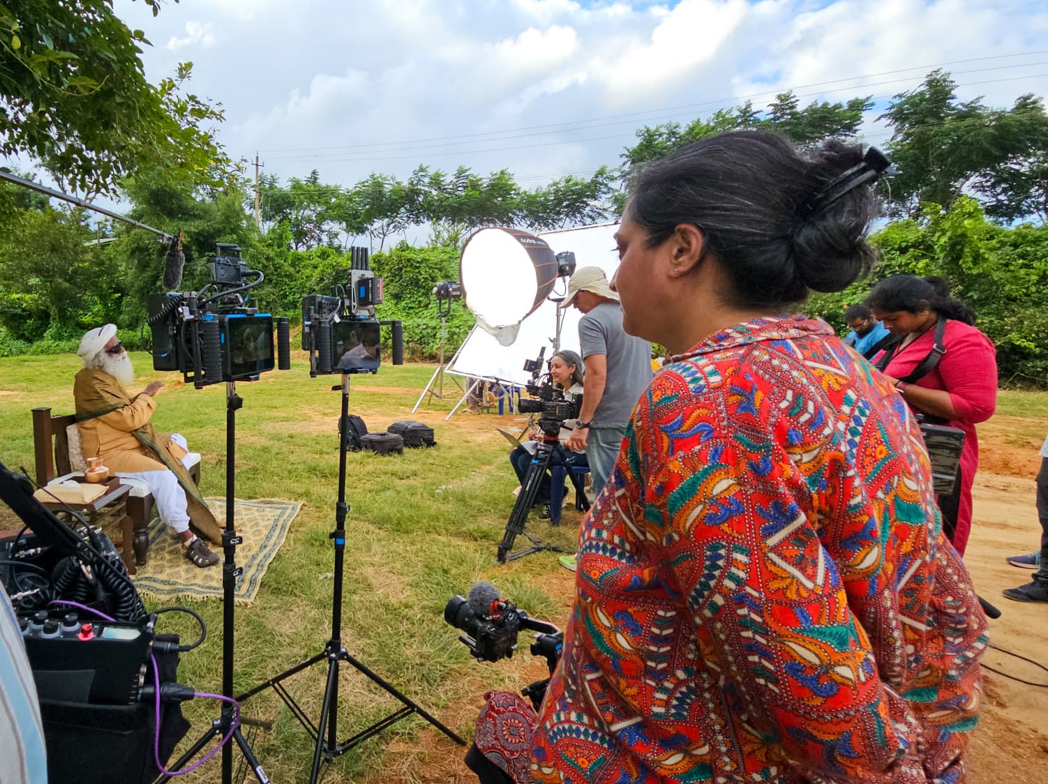 Crew member beside the camera rig and lighting umbrella during a shoot